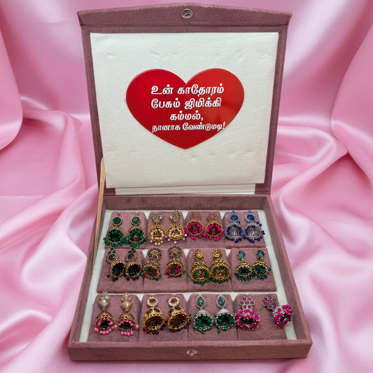 Box of earrings with a heart-shaped card on a pink background